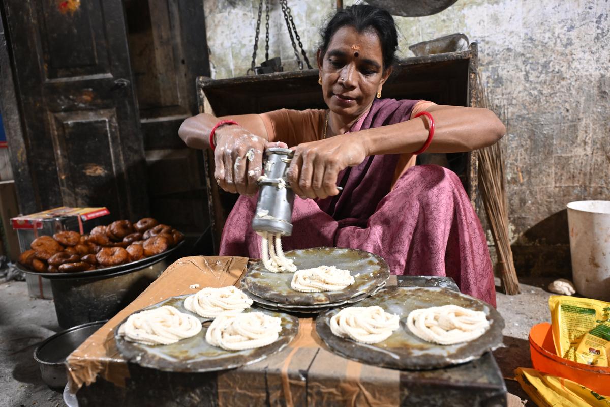 One of the women at Sumangali Home Industry shaping crispy murukku in Madurai.. One of the women at Sumangali Home Industry shaping crispy murukku in Madurai..
