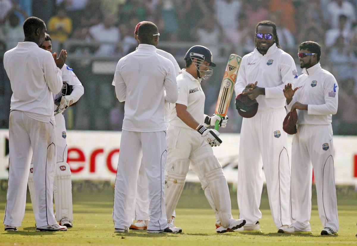 West Indian players clap to pay their respect to Sachin Tendulkar as he arrives to bat for the last time in Test cricket on Day 1 of their 2nd Test match at Wankhede Stadium in Mumbai on Novemebr 14, 2013.