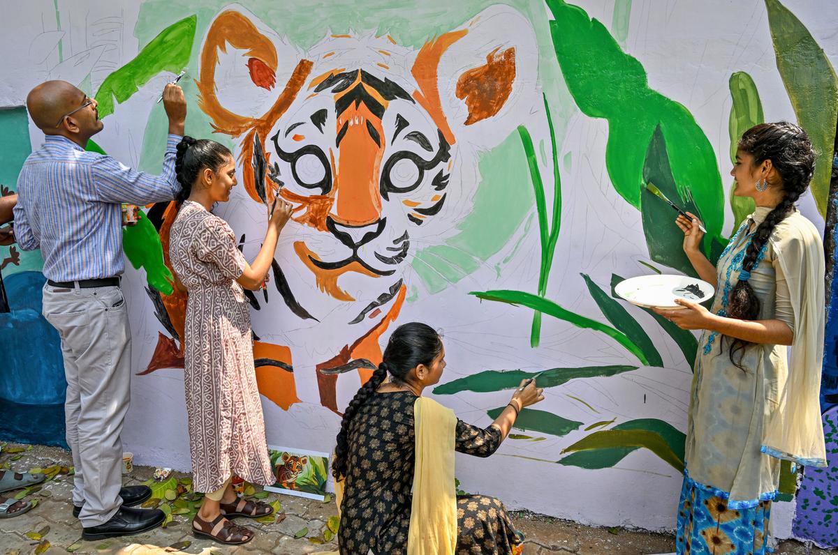 People  painting the wall with various environmental themes behind All India Radio Station at Siripuram as part of Paint My Street initiative of GVMC in Visakhapatnam on Tuesday