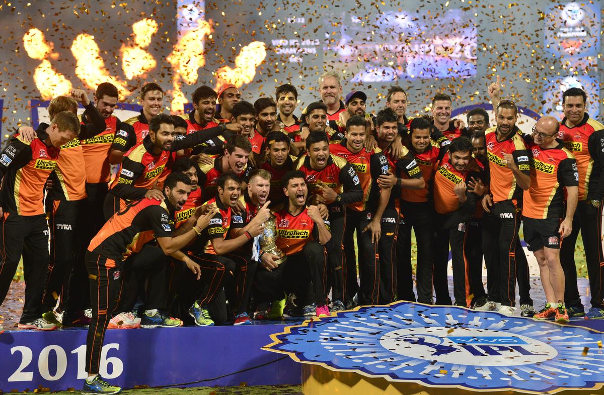 Sunrisers Hyderabad team captain David Warner and team members celebrate with the trophy after winning the Indian Premier League (IPL) Twenty20 cricket championship 2016, defeating Royal Challengers Bangalore in the final at the M. Chinnaswamy Stadium (KSCA) in Bengaluru on May 29, 2016.   