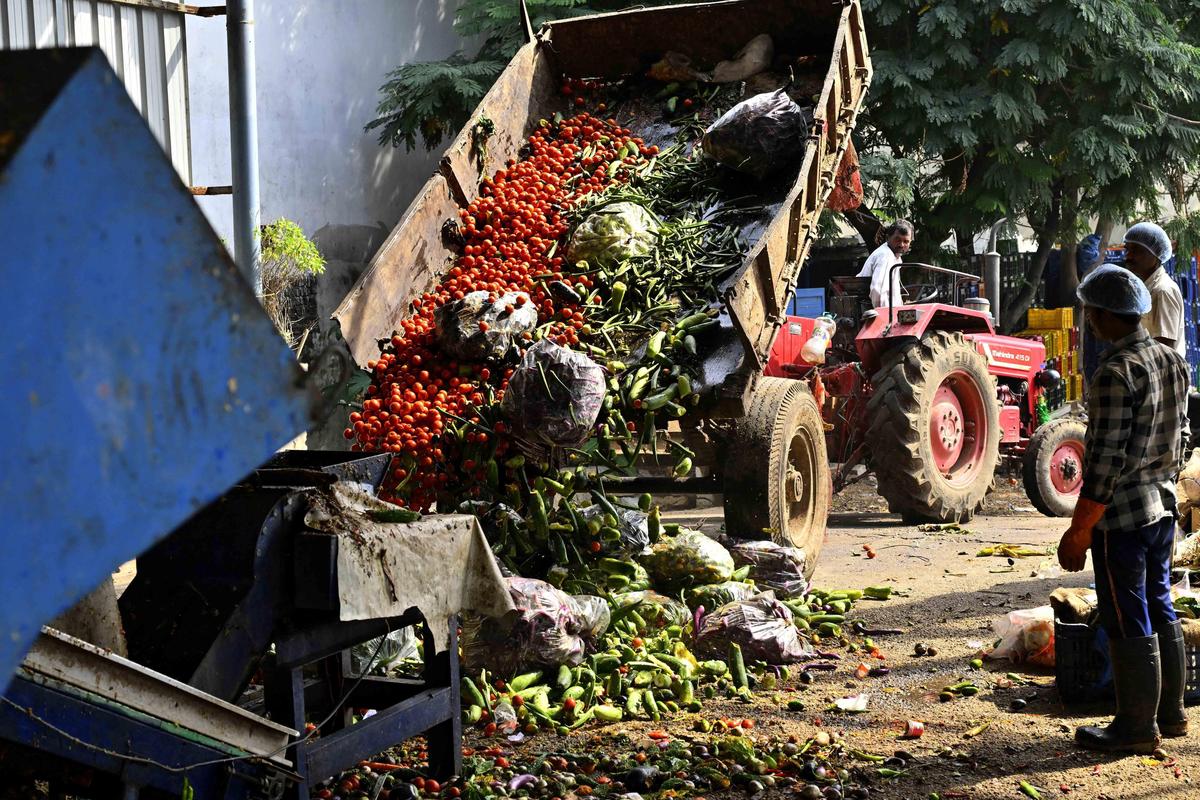 Workers dump vegetable waste at Dr. B.R. Ambedkar Vegetable Market Yard in Bowenpally.