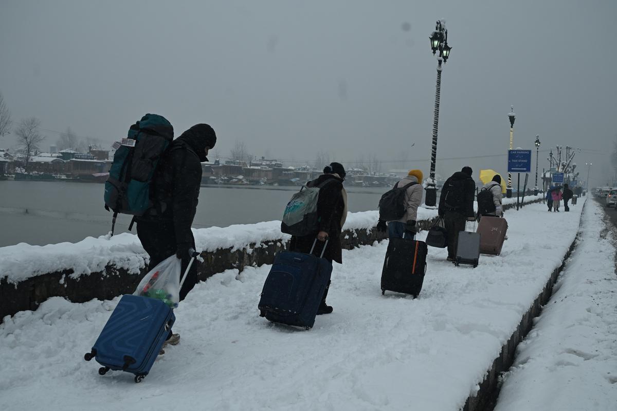Tourists along with lagguages banks of Dal lake during heavy snowfall in Srinagar, 28 December 2024. 