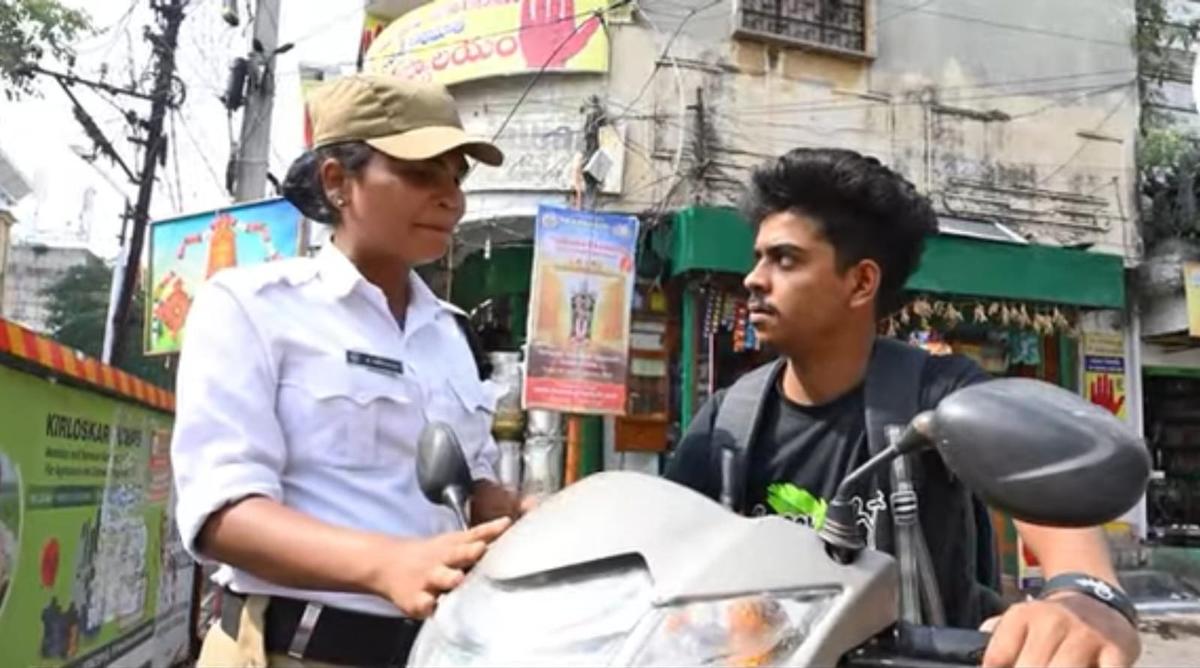 के श्रीवल्ली महंकाली में एक व्यस्त जंक्शन पर वाहन चलाते समय एक मोटर चालक को हेलमेट पहनने के लिए मार्गदर्शन कर रहे हैं