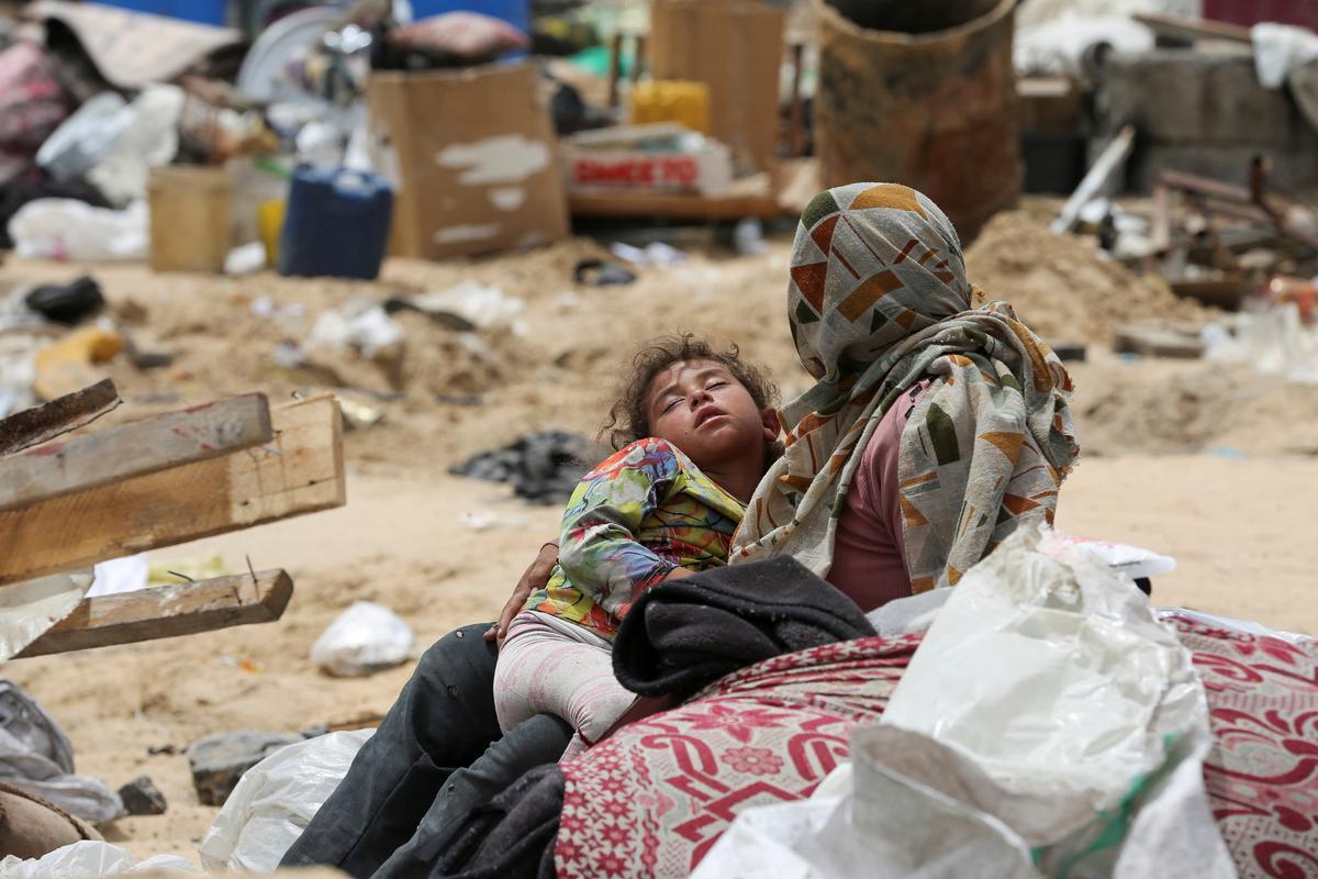 A child rests on the day Palestinians travel on foot along with their belongings, as they flee Rafah due to an Israeli military operation, in Rafah, in the southern Gaza Strip, on May 28, 2024. 