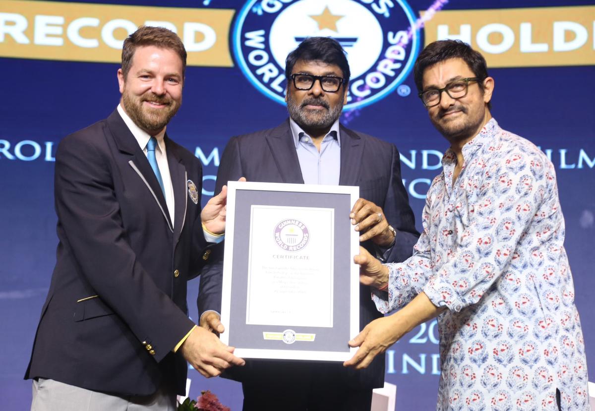 Actor Chiranjeevi receives the citation from a representative of the Guinness World Records in Hyderabad on Sunday. Bollywood actor Aamir Khan is also seen.