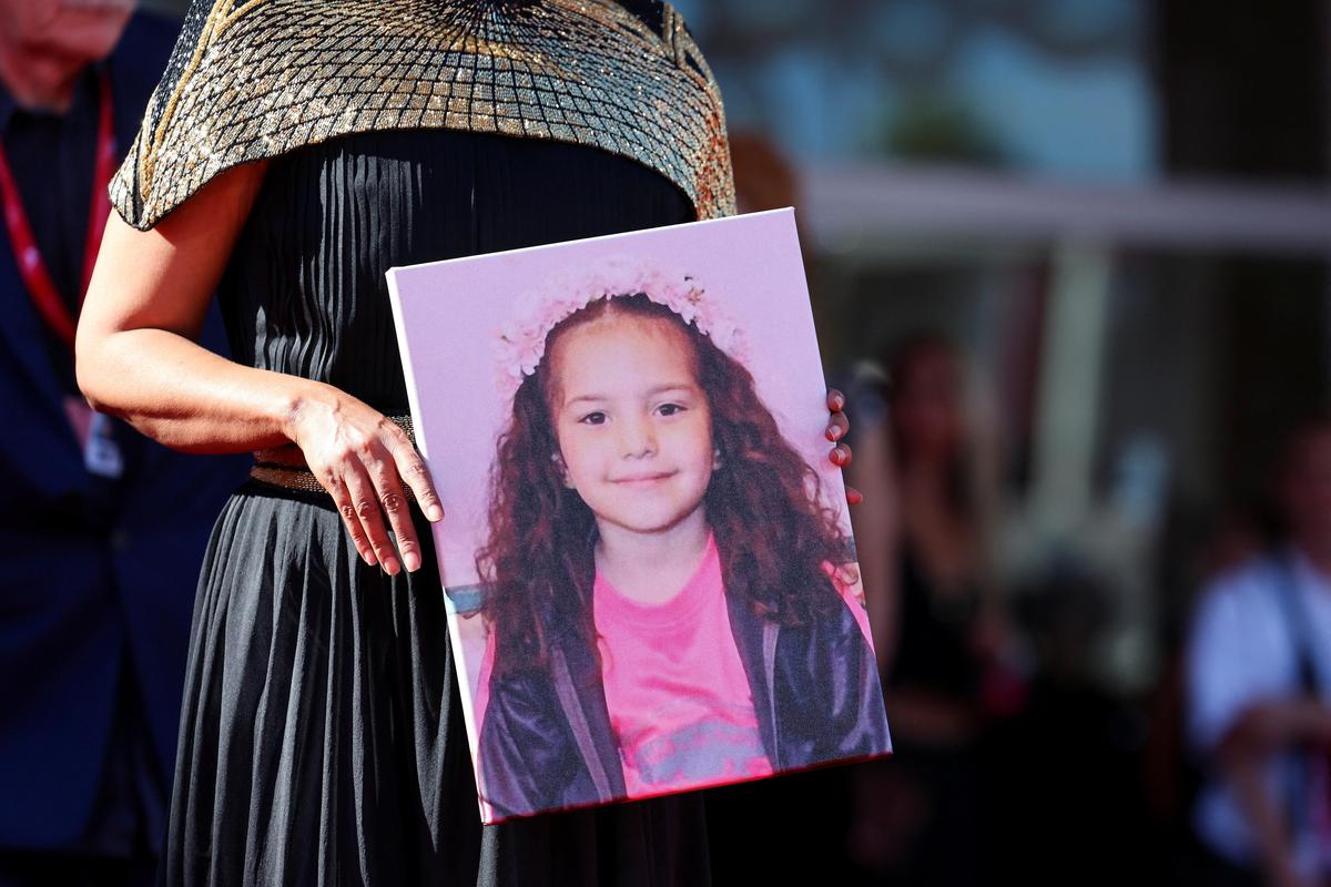 Kaouther Ben Hania holds a picture of Hind Rajab on the red carpet during arrivals for the screening 'The Voice of Hind Rajab' in competition, at the 82nd Venice Film Festival, Venice, Italy, September 3, 2025.