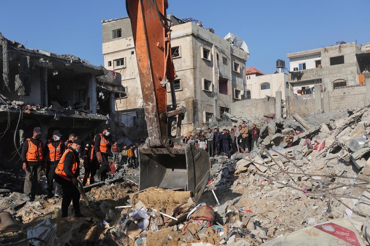 Palestinians search for victims at the site of an Israeli raid on a house, amid the ongoing conflict between Israel and the Palestinian Islamist group Hamas, in Rafah, southern Gaza Strip, on December 19, 2023.