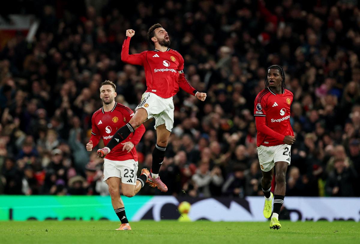 Manchester United's Bruno Fernandes celebrates scoring their third goal with Luke Shaw and Ayden Heaven