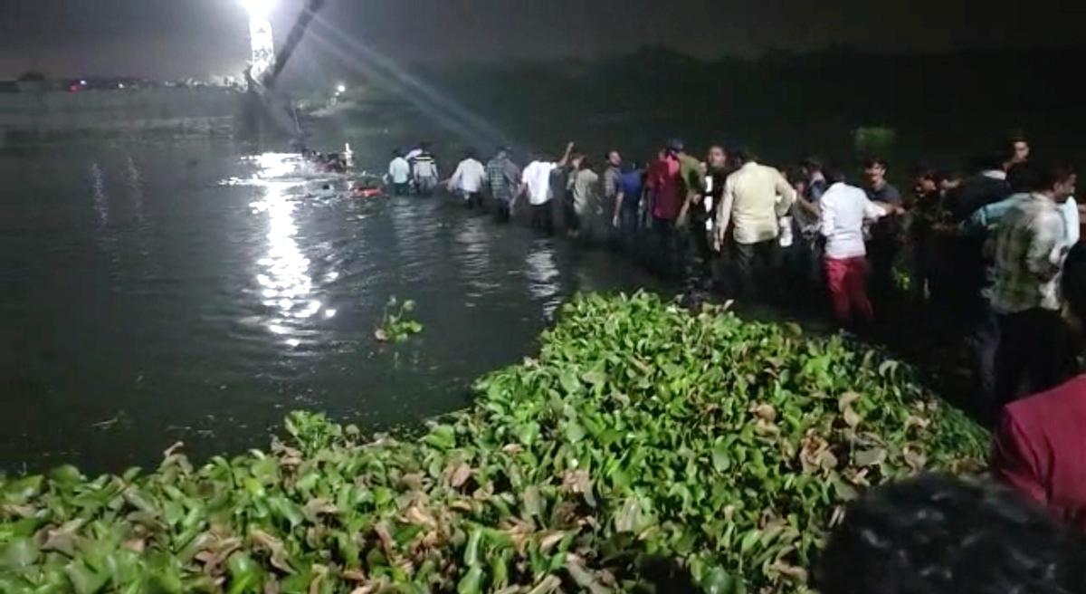 Rescue operation unde rway after an old suspension bridge over the Machchhu river collapsed, in Morbi district on October 30, 2022. 