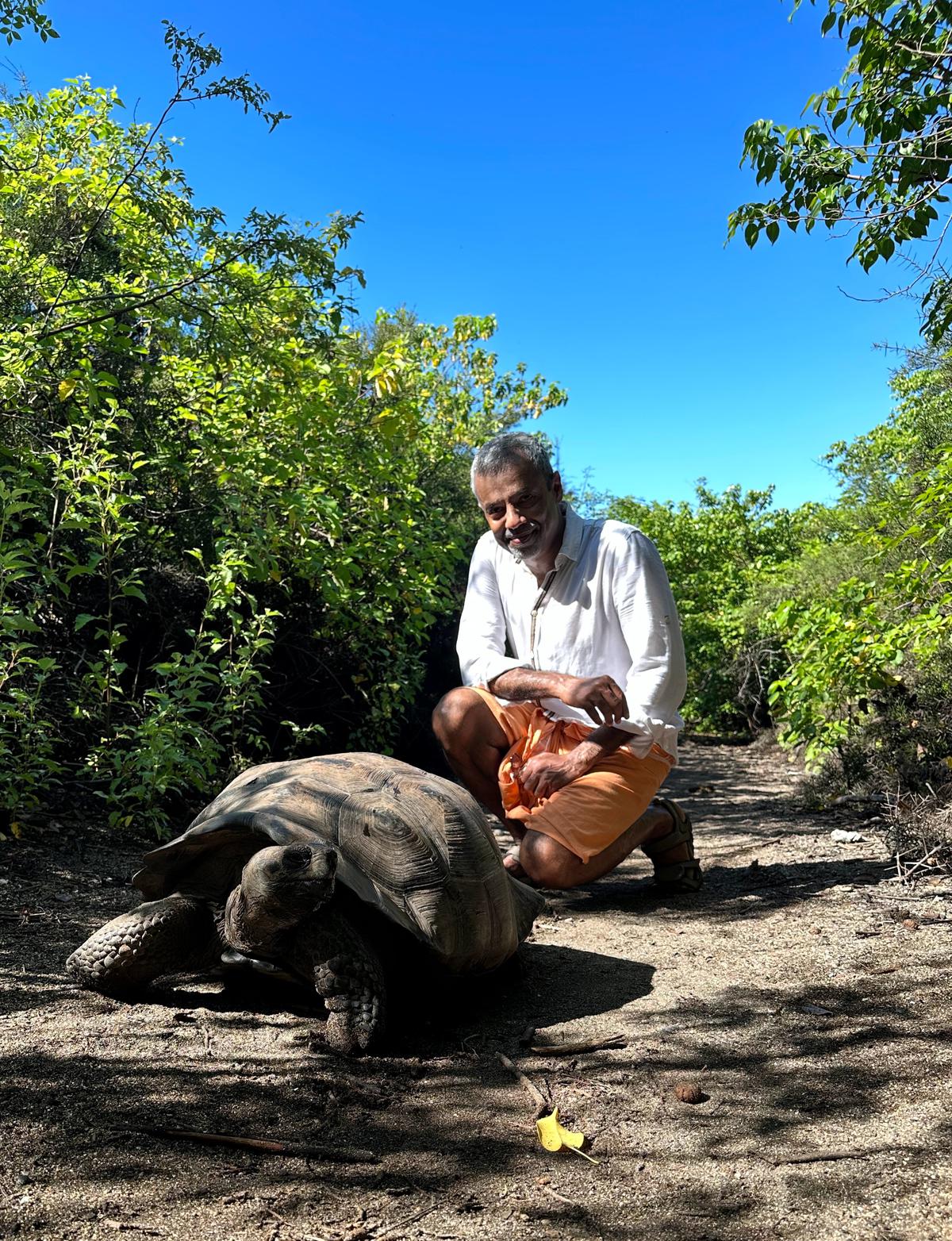 Former investment manager Anand Vasudevan and a  150-year-old male Galapagos Giant Tortoise at the Charles Darwin Research Station in Santa Cruz Island.