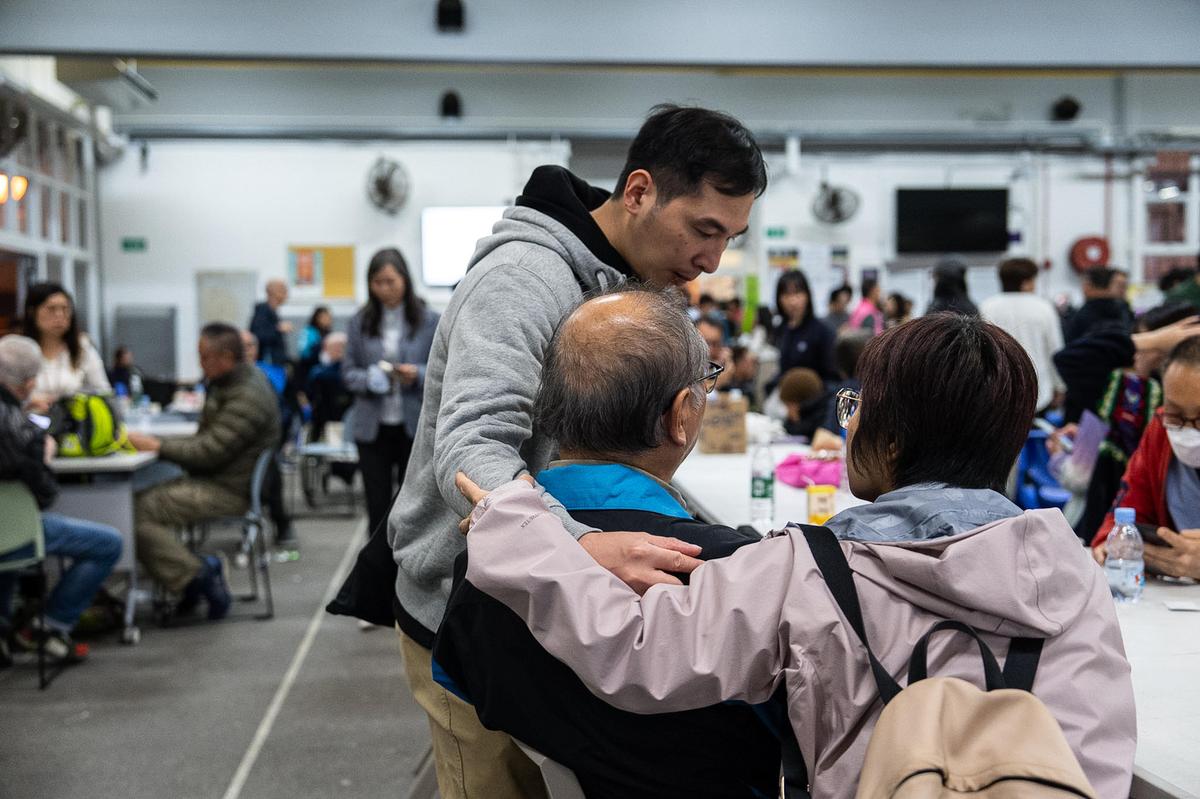 Residents rest at a temporary shelter after a fire broke out at Wang Fuk Court, a residential estate in the Tai Po district of Hong Kong’s New Territories, on November 26 2025.