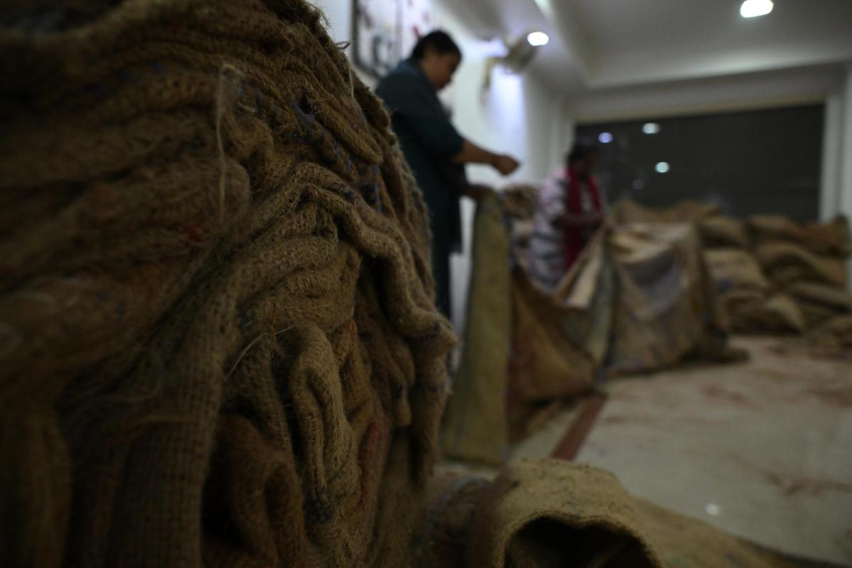 मट्टनचेरी के एसएमएस हॉल में कुदुम्बश्री के सदस्य जूट के बोरे सिलाई करते हुए  