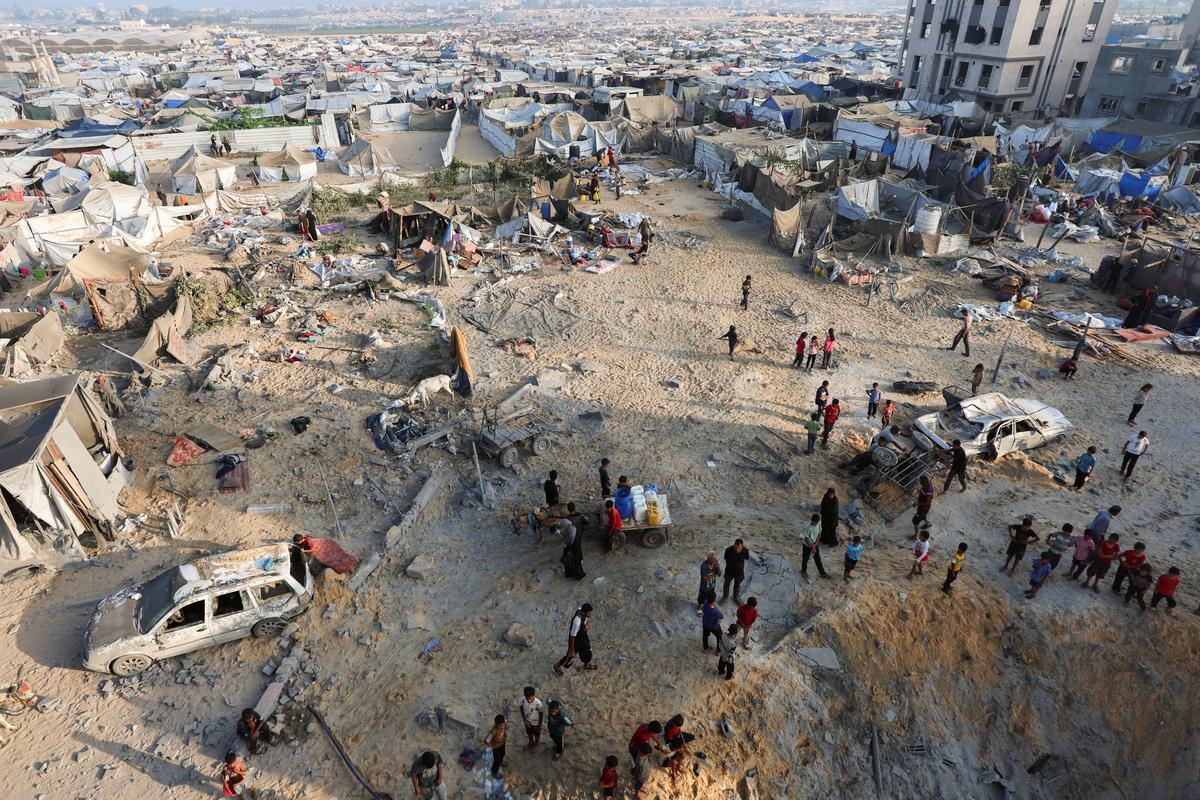 Palestinians gather at the site of an overnight Israeli air strike on a house, in Khan Younis in the southern Gaza Strip, July 28, 2025.