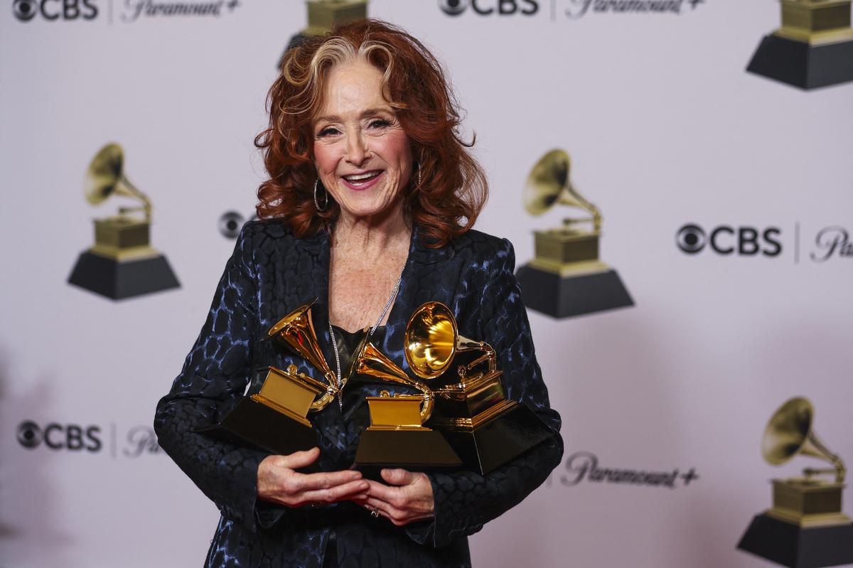 Bonnie Raitt poses with her awards for Best Americana Performance, Best American Roots Song and Song of the Year during the 65th Annual Grammy Awards in Los Angeles.