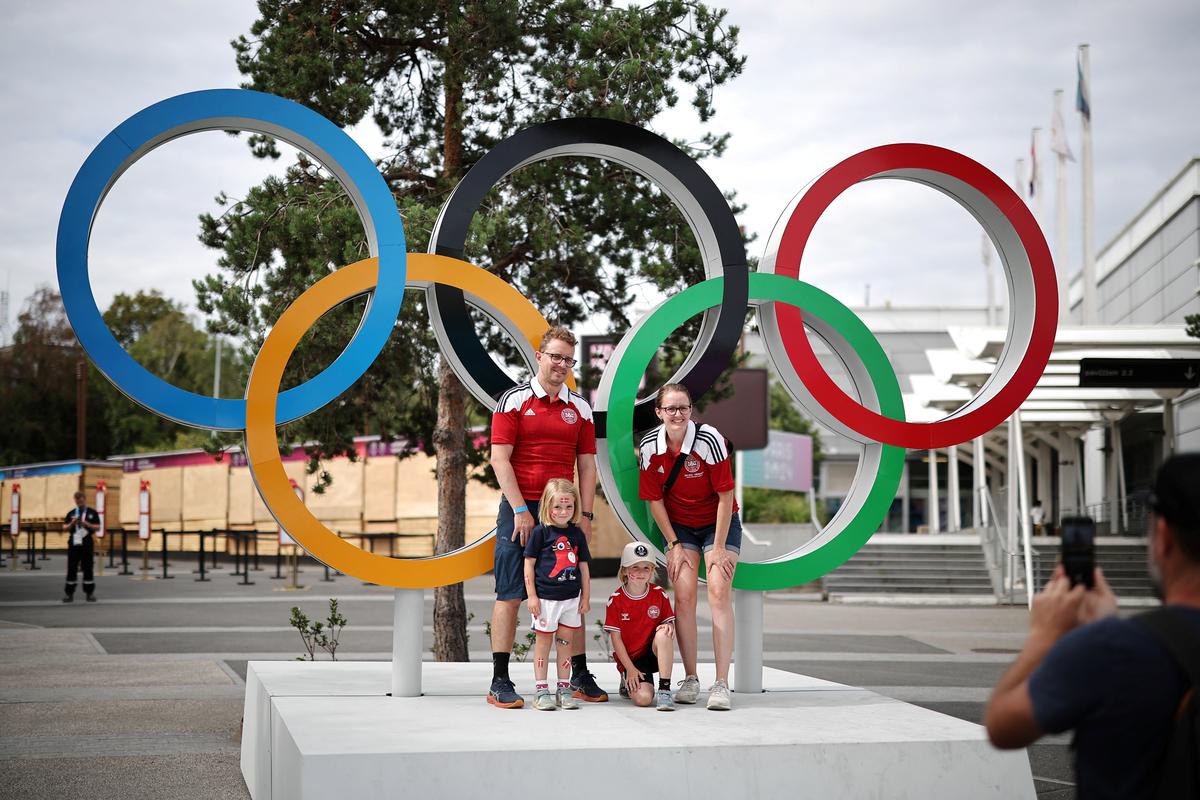A family poses for photographs with the Olympic Rings at South Paris Arena 4, ahead of the Paris 2024 Olympic and Paralympic Games, in Paris, on July 25, 2024.