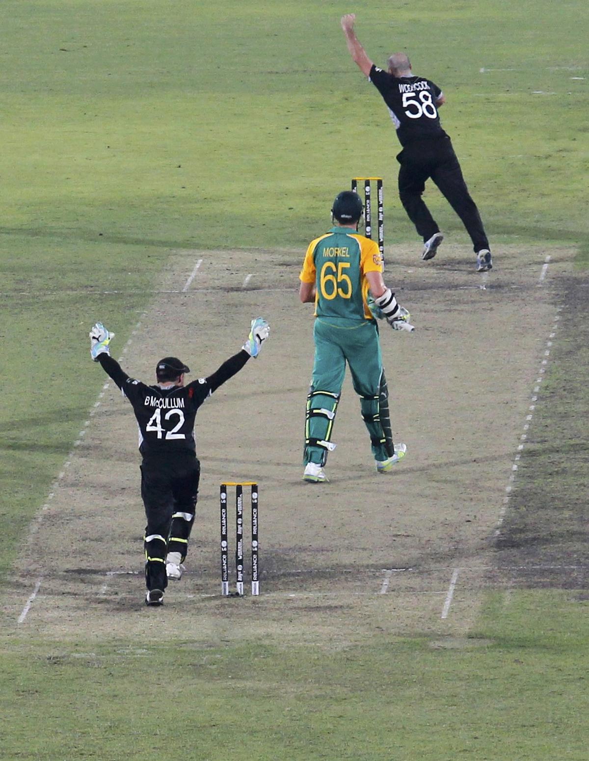New Zealand’s Luke Woodcock and Brendon McCullum (L) celebrate taking the wicket of South Africa’s Morne Morkel to win their Cricket World Cup quarterfinal match in Dhaka March 25, 2011.   
