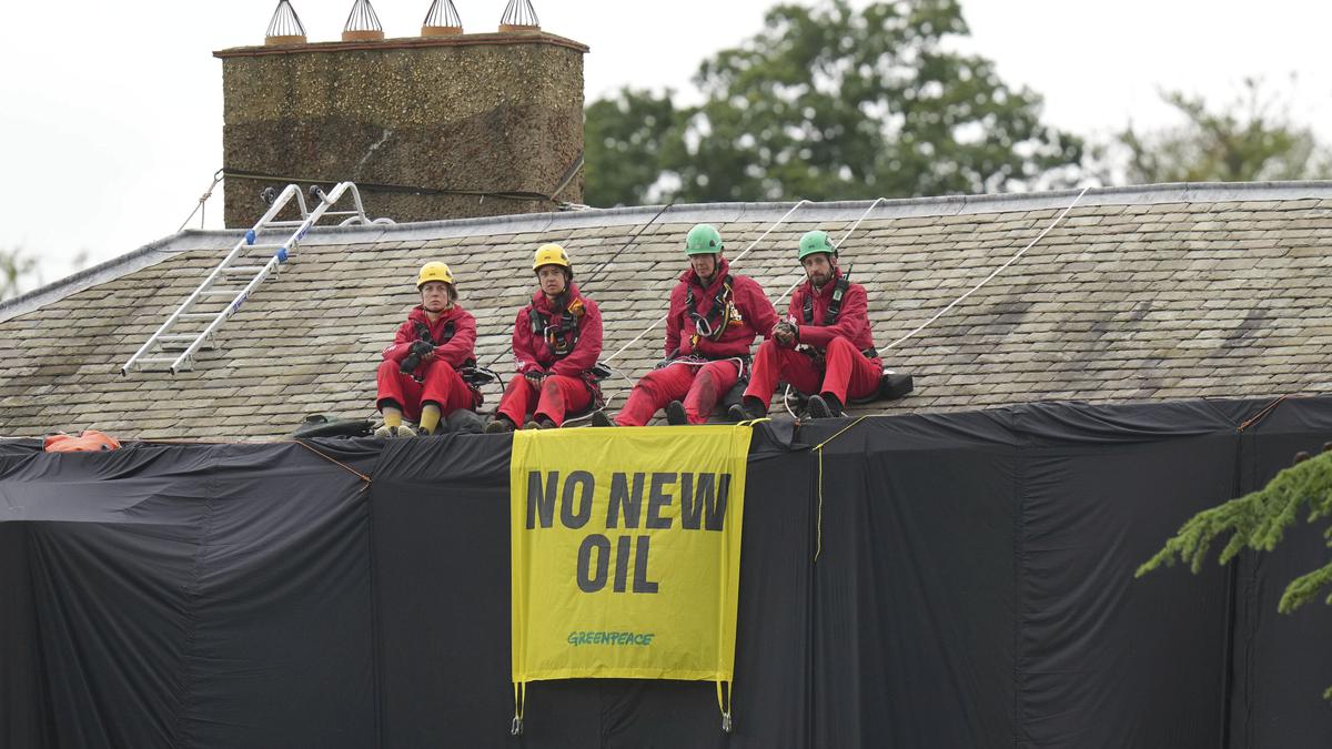 Greenpeace demonstrators drape U.K. prime minister's house in black to protest oil expansion