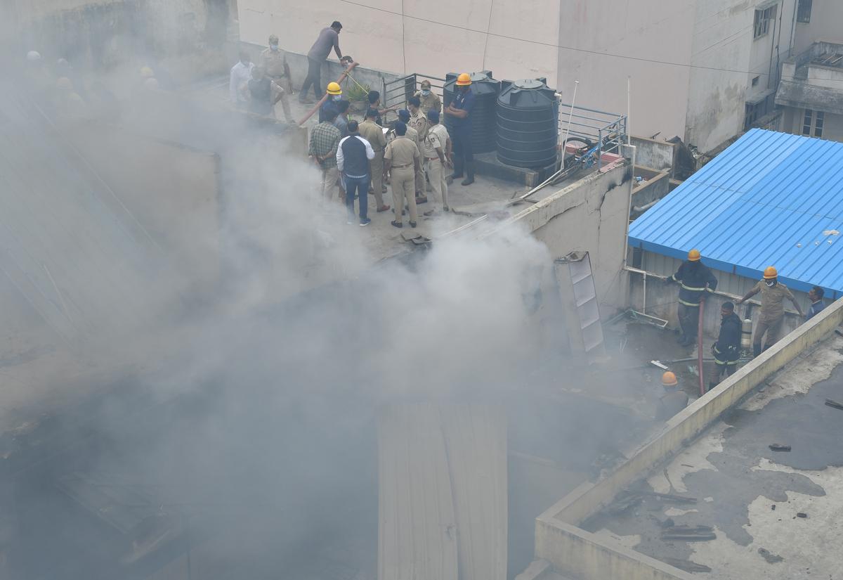 Police and fire service personnel carrying out rescue operations at Nagarathpete in Bengaluru on Saturday.
