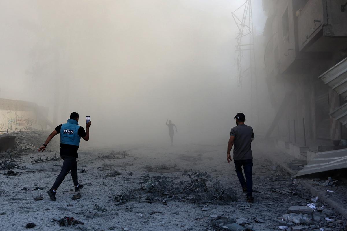 A journalist rushes towards the scene of an explosion following an Israeli strike, which reportedly targeted a school in the Zeitoun district on the outskirts of Gaza City, on September 1, 2024. 