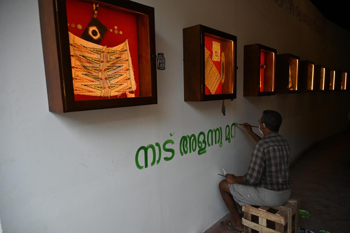 Un trabajador pinta el texto de la obra de un artista participante en la sexta edición de la Bienal Kochi-Muziris en Aspinwall House en Fort Kochi el jueves. 