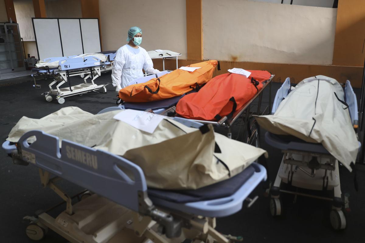 A medical worker tends to bodies of victims of soccer match stampede at the Saiful Anwar Hospital in Malang, East Java, Indonesia on October 2, 2022. 