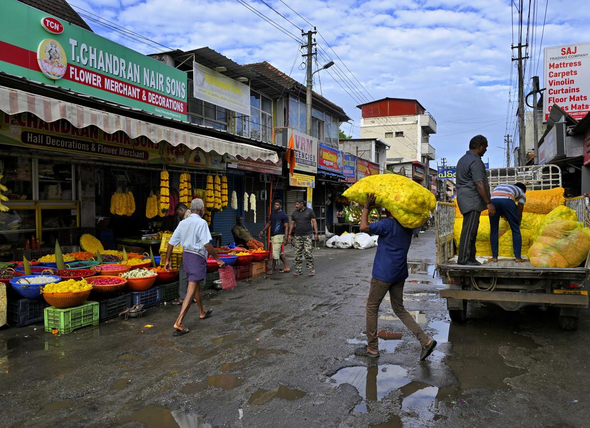 Workers unloading fresh stock of flowers that arrived from Tamil Nadu at Chala market.