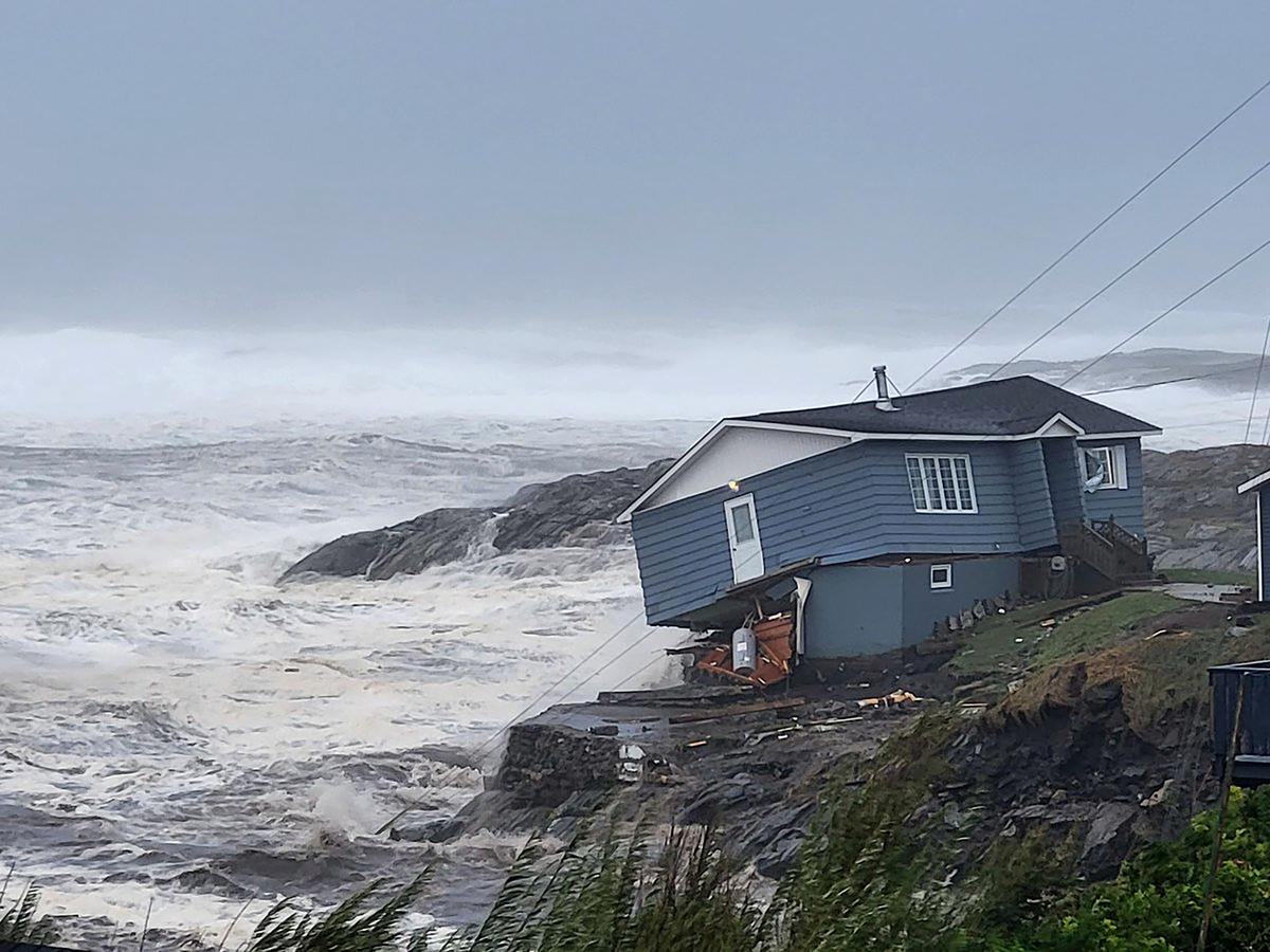 In this photo provided by Wreckhouse Press a home fights against high winds caused by post-Tropical Storm Fiona in Port aux Basques, Newfoundland and Labrador, on Saturday, September 24, 2022. The home has since been lost at sea. 