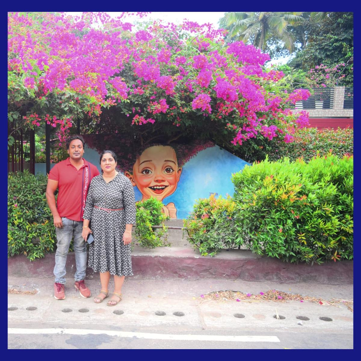 Santhosh Kumar and wife Rekha Santhosh near the wall art on the wall of their house in Thirupuram in Thiruvananthapuram district