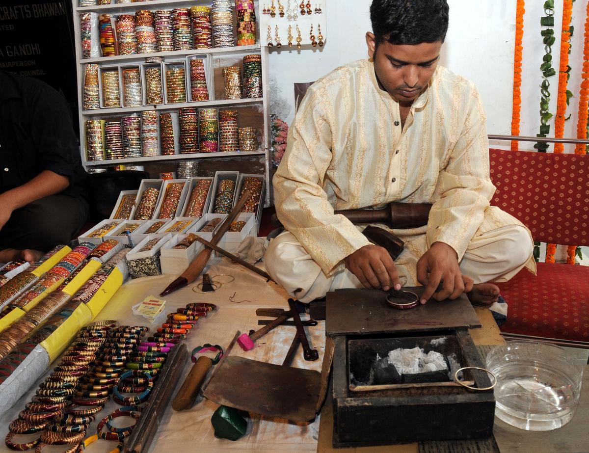 An artist making bangles with lac An artist making bangles with lac