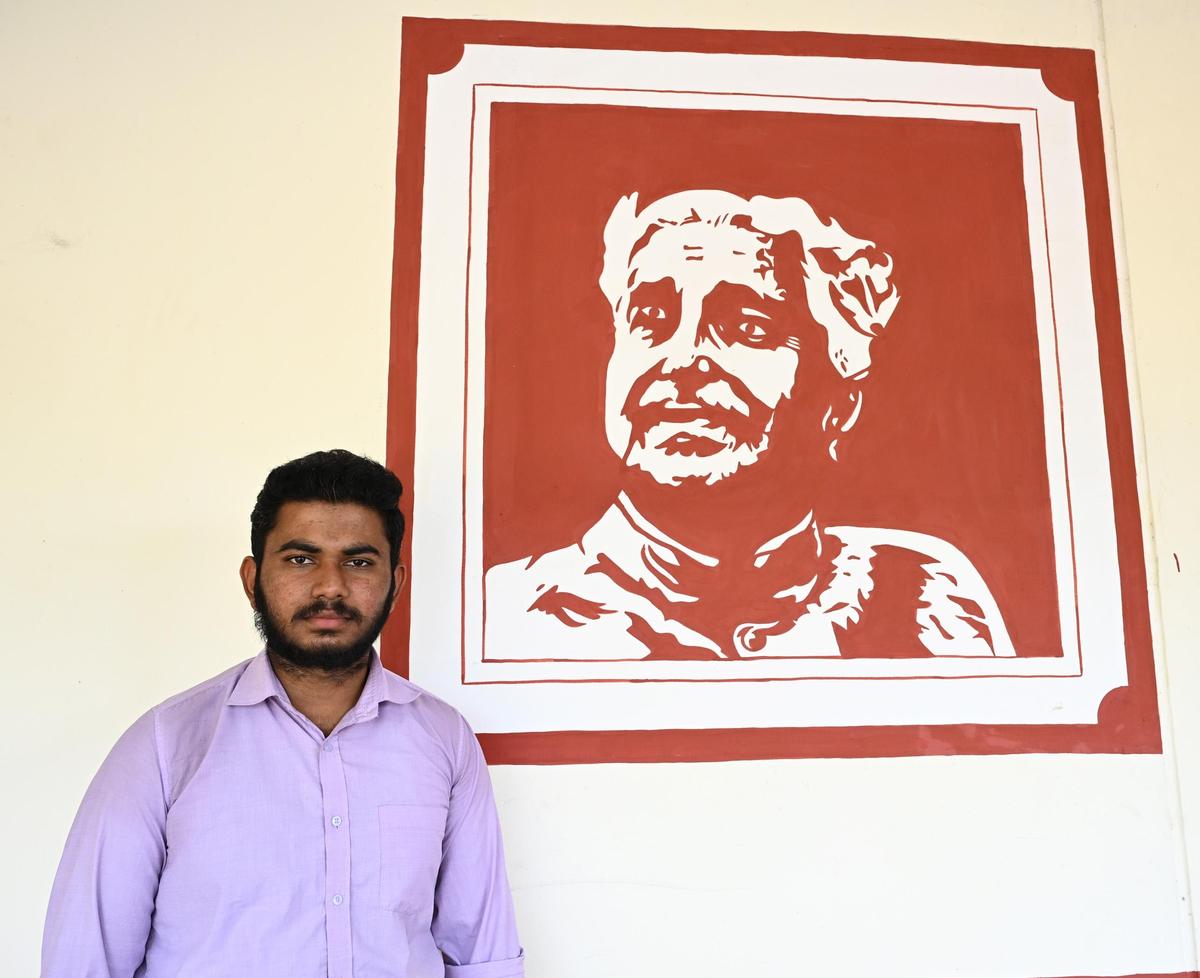Rihan A.,with his portrait of Kuvempu at the entrance of Sahyadri Commerce and Management College in Shivamogga, Karnataka.