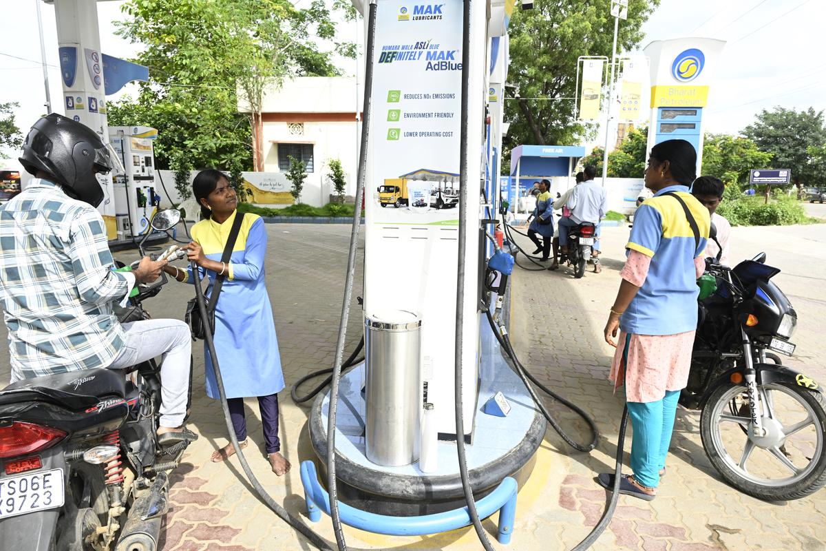Employees of the petrol bunk dispensing fuel.