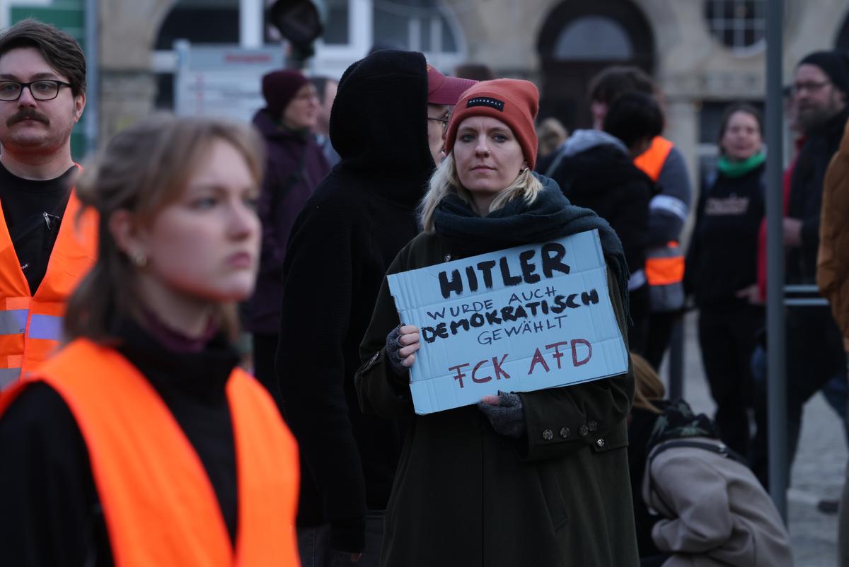 People protesting against a nearby rally of the far-right Alternative for Germany (AfD), including one woman with a placard that reads: “Hitler was also democratically elected, FCK AFD”, march before German elections on February 22, 2025 in Erfurt, Germany. 