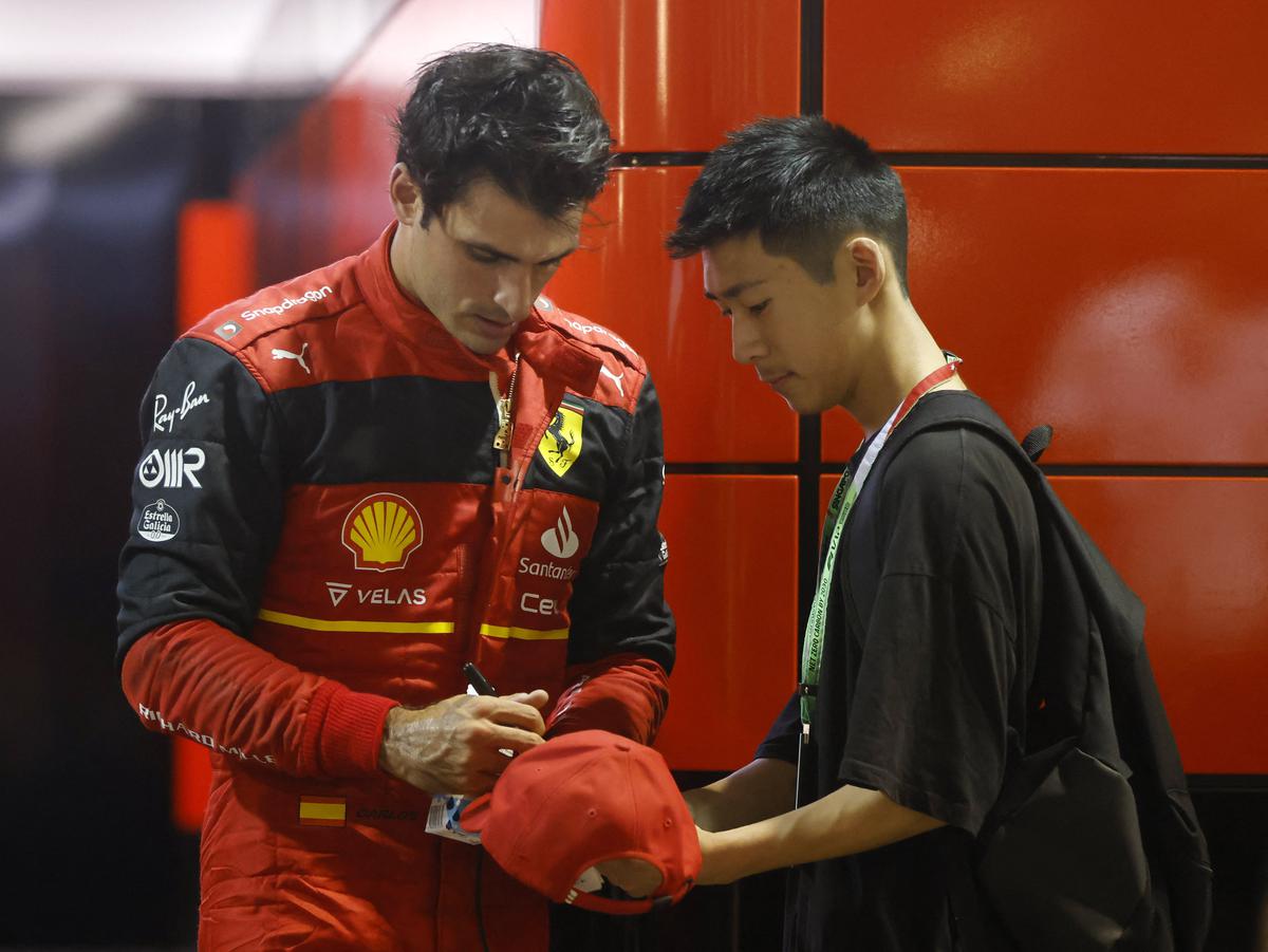Ferrari’s Carlos Sainz Jr. signs a cap for a fan after the second practice session of Formula One Singapore Grand Prix at the Marina Bay Street Circuit, Singapore on September 30, 2022.