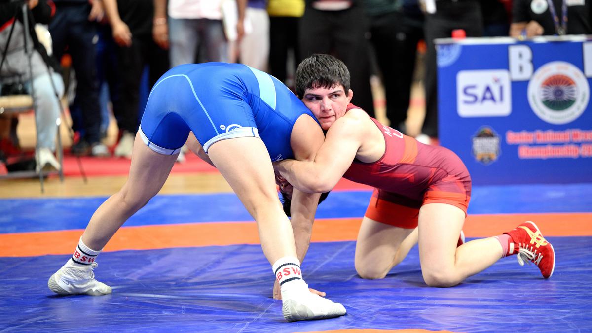 Haryana's Manisha Bhanwala, in red, in action against Delhi's Neha Sharma in the women's 57kg gold medal match at the National Wrestling Championship in Ahmedabad on Friday, December 12, 2025. 