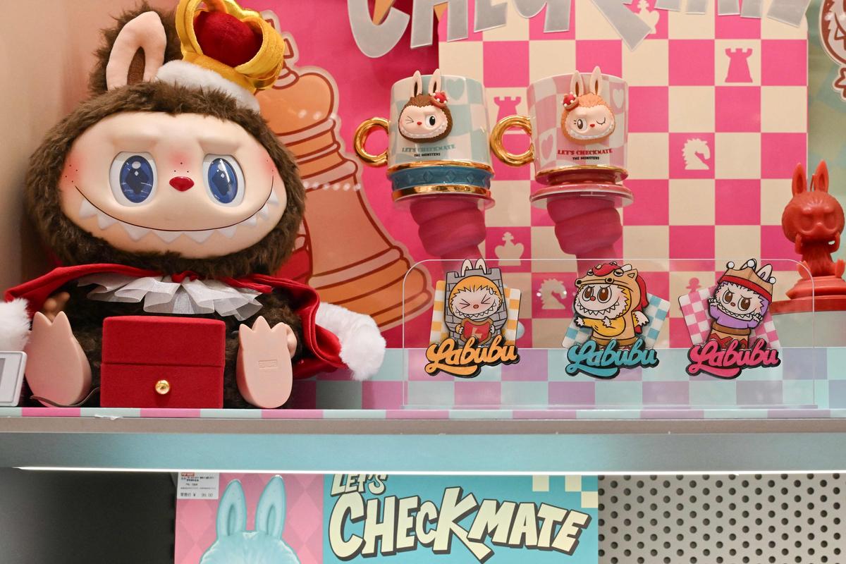 A not-for-sale Labubu figure (left) and Labubu stickers are seen at a Pop Mart shop. A Beijing auction house has sold a four-foot-tall sculpture of a viral plush toy character for more than $150,000, as global demand for the Chinese-designed Labubu dolls reaches fever pitch. 