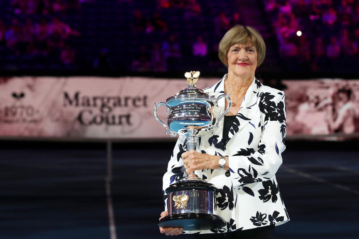Margaret Court lifts a replica Daphne Akhurst trophy on Rod Laver Arena. 