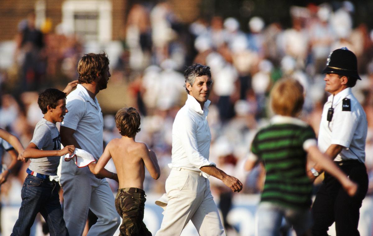 England captain Mike Brearley (centre) leaves the field as spectators rush on at the Oval on August 29, 1981, in London.