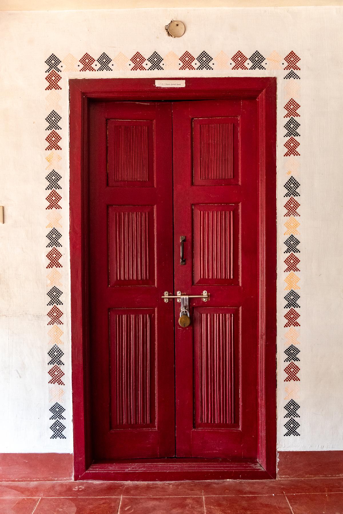 A fish-shaped border design ‘Bagilu chittara’ adorns the wall of a doorway at Kannada University Study Centre, Kuppali.