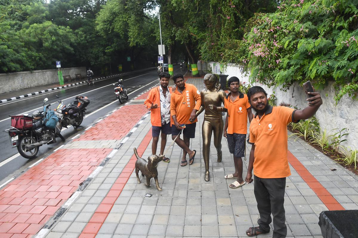 Passers-by take a selfie with a statue at the Health Walk stretch on Besant Avenue 