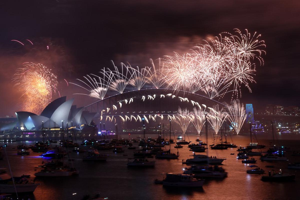 New Year’s Eve fireworks light up the sky over the Sydney Opera House (L) and Harbour Bridge during the fireworks display in Sydney on January 1, 2023.