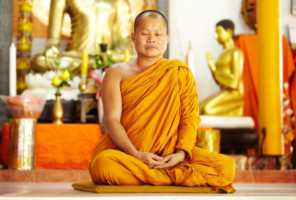 A monk meditating at a shrine.