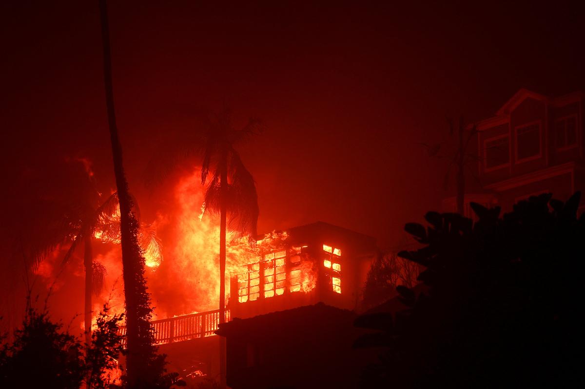 Flames rise from homes along the Pacific Coast Highway towards Malibu as a wildfire burns in the Pacific Palisades neighborhood of west Los Angeles, California, U.S. on January 7, 2025. 