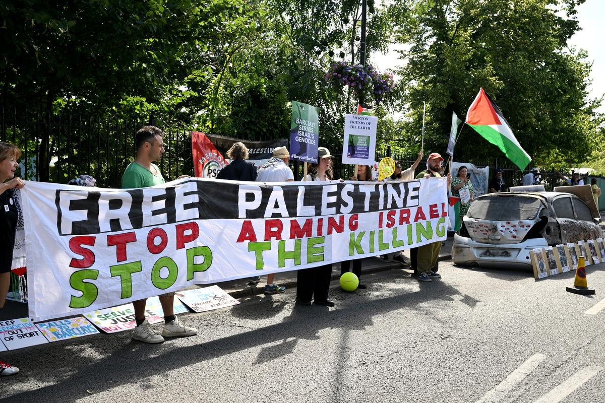 Protesters hold a banner reading “Free Palestine, Stop Arming Israel, Stop the Killing” during a protest against Barclays bank, a Wimbledon sponsor, on the first day of the Wimbledon Championships on June 30, 2025. Protesters hold a banner reading “Free Palestine, Stop Arming Israel, Stop the Killing” during a protest against Barclays bank, a Wimbledon sponsor, on the first day of the Wimbledon Championships on June 30, 2025.