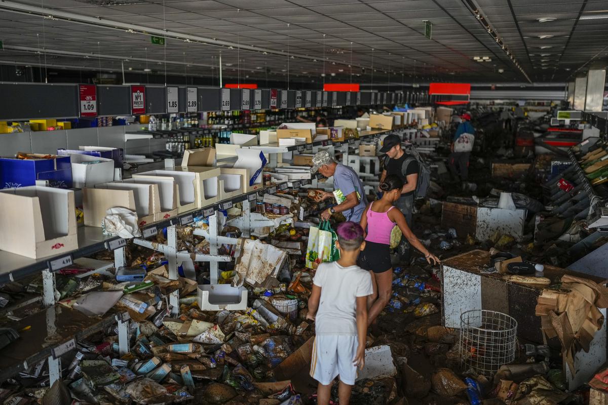 People pick up goods in a supermarket affected by the floods in Valencia, Spain, on Thursday (October 31, 2024).