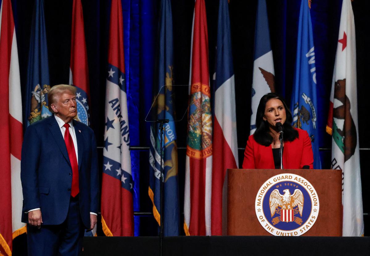 Republican presidential nominee and former U.S. President Donald Trump listens as former Democratic presidential candidate Tulsi Gabbard speaks in Detroit, Michigan, U.S., on August 26, 2024.