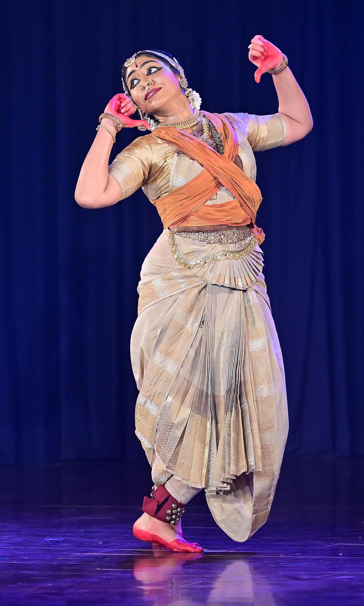 गुहा का चित्रण करतीं सौजन्या सुरेश। गुहा की आदिवासी पहचान का सुझाव देने के लिए क्रॉस-पहने हुए कवि कपड़े का उपयोग किया जाता है।