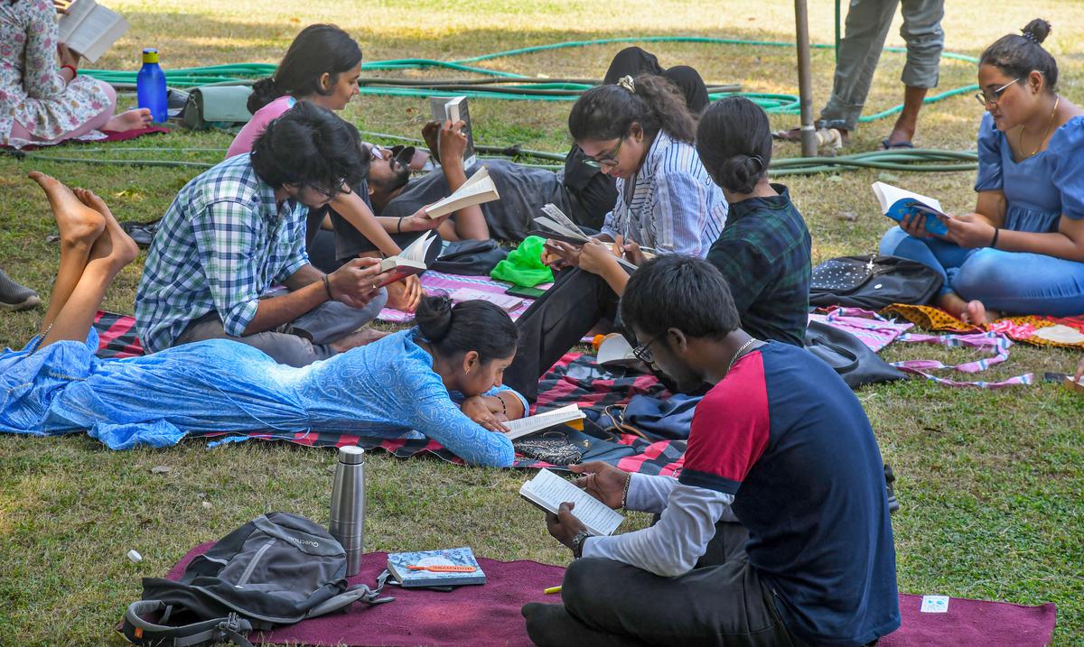 People reading books under the shade of trees at VMRDA Central Park as part of a quiet reading initiative called Vizag Reads in Visakhapatnam.