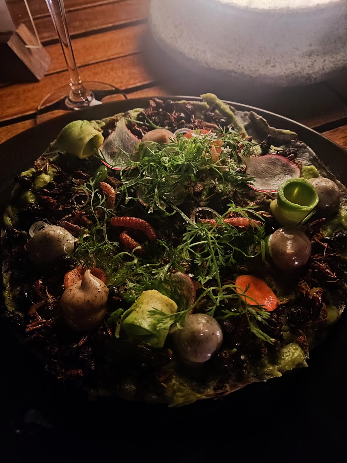 Casa Oaxaca’s ‘tostada de insectos’, a crisp corn shell topped with chicatana ants, chapuline grasshoppers and agave worms around swirls of guacamole and herbs.