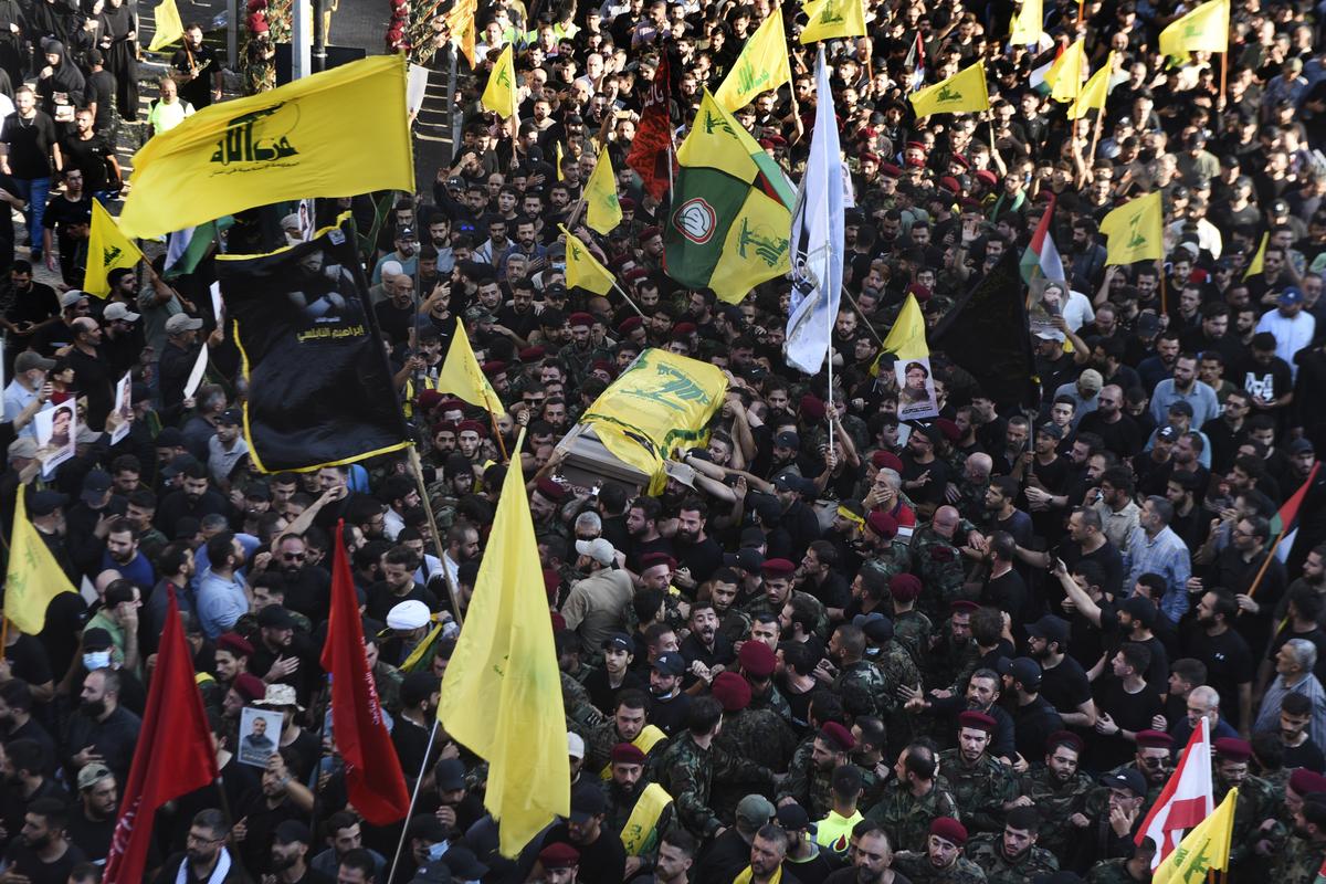 Mourners and Hezbollah fighters carry the coffin of their top commander Fouad Shukur who was killed by an Israeli airstrike on July 30, during his funeral procession in a southern suburb of Beirut, Lebanon.