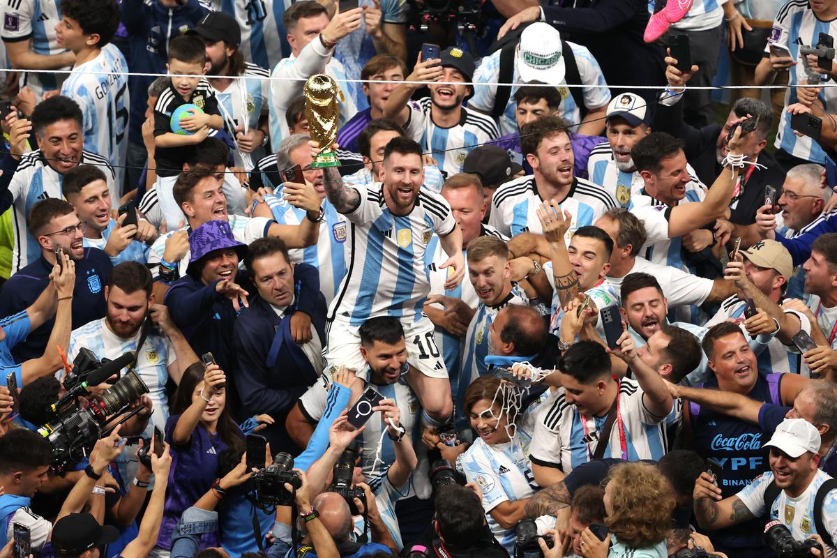 Lionel Messi of Argentina celebrates with the FIFA World Cup Qatar 2022 Winner’s Trophy on the shoulders of former teammate Sergio Aguero after the team’s victory during the FIFA World Cup Qatar 2022 Final match between Argentina and France at Lusail Stadium on December 18, 2022, in Lusail City, Qatar. 